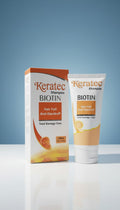 Keratec Biotin shampoo packaging on a reflective surface with a blue gradient background